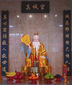 an image of a buddha statue with fruits and vegetables around it