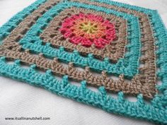 a crocheted square with a flower in the center