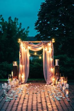 an outdoor wedding setup with candles and lights