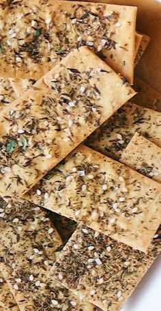 a bunch of crackers that are sitting on a white table top with some seeds all over them