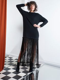 High-necked fine knit dress with detachable extra-long fringes at the hem line. Can be worn as a maxi dress, a mini dress or as a maxi pullover. Composition: 100% Wool Material 2: 100% Polyester  Keep away from fire!  MANUFACTURER INFORMATION: Helene Galwas GmbH Schlosshof 7 82229 Seefeld Germany Phone: +49 89 416 137 431 E-Mail: shop@helenegalwas. de Evening Maxi Dress With Tassels, Spring Maxi Dress With Fringe, Spring Black Maxi Dress With Fringe, Black Maxi Dress With Fringe For Spring, Chic Maxi Length Dresses With Tassels, Black Fringe Maxi Dress For Spring, Chic Maxi Dress With Tassels, Long Sleeve Fringe Dress For Fall, Evening Midi Dress With Tassels