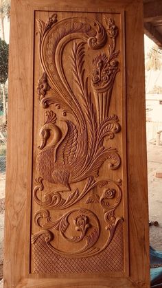 an intricate carved wooden panel in the shape of a peacock