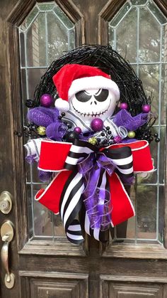 a wreath with a skeleton on it is hanging in front of a door decorated for halloween