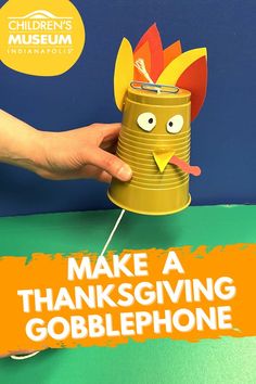 A gold plastic cup is turned upside down and decorated with eyes, a beak, and feather made out of paper. There's a string coming out of the bottom of the cup with a hand pulling it tight. Turkey Craft For Kindergarteners, Turkey Thumbprint Craft, Thanksgiving Craft School Age, Easy Thanks Giving Crafts For Kids, Thanksgiving Dinner Crafts For Kids, Stem Turkey Activities, Thanksgiving Themed Stem Activities, Steam Thanksgiving Activities, November Enrichment Activities