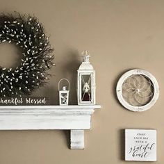 a mantle with a wreath, lantern and other items on it