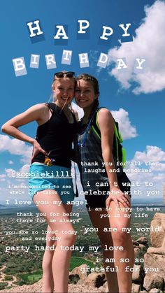 two girls are posing for the camera with their arms around each other on top of a mountain