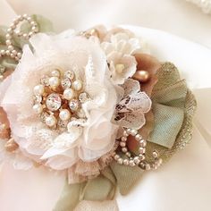 a close up of a flower with pearls and lace on it's headband