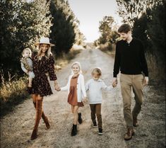 a family walking down a dirt road holding hands