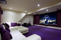 a living room with purple carpet and white couches in front of a flat screen tv