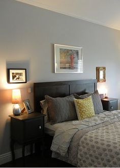 a bedroom with a bed, nightstands and pictures on the wall