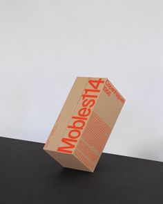 a cardboard box sitting on top of a black table next to an orange and white object