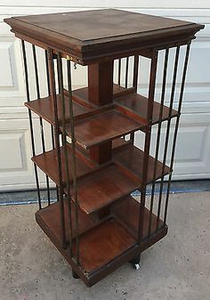 a wooden shelf with metal bars and shelves on wheels in front of a garage door