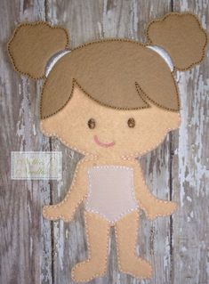 an appliqued doll is shown on a wooden background with the word,