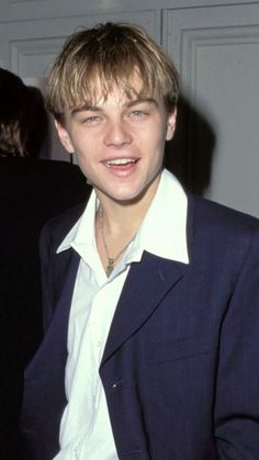 a young man wearing a suit and white shirt