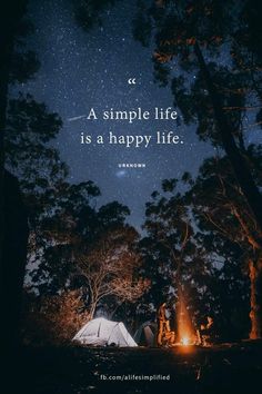 a campfire in the woods with a quote about a simple life is a happy life