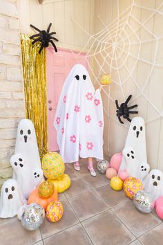 there is a woman standing in front of the door with ghost decorations and balloons on the floor