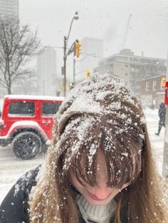 a woman is standing in the snow with her head down and she's covering her eyes