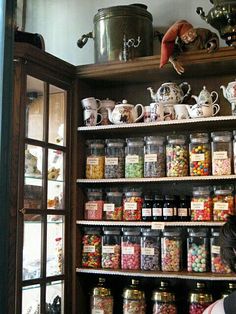 a woman standing in front of a shelf filled with lots of candy