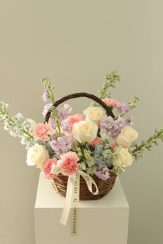 a basket filled with flowers sitting on top of a white box