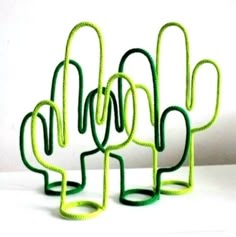 three green cactus sculptures sitting on top of a white table