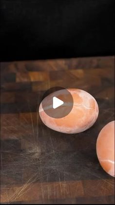 two uncooked eggs sitting on top of a wooden table next to each other