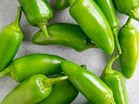 some green peppers are laying on the counter