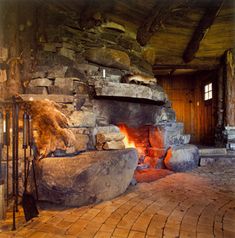 an old stone fireplace in a rustic log cabin