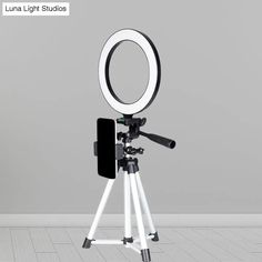 a tripod with a light on it in front of a gray wall and floor