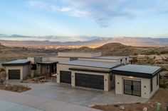 a large house with two garages and mountains in the backgrouund area