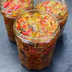 three jars filled with pickled vegetables on top of a table