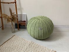 a large green ball sitting on top of a floor next to a chair and rug