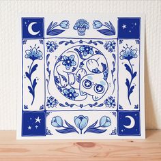 a blue and white tile with an image of two dogs in the center surrounded by flowers