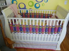 a baby crib in a room with yellow walls and blue circles painted on the wall