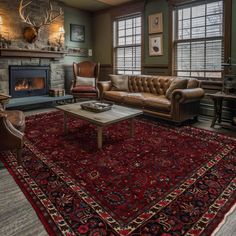 a living room filled with furniture and a red rug on top of a wooden floor