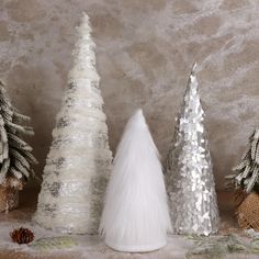 three white and silver christmas trees sitting next to each other