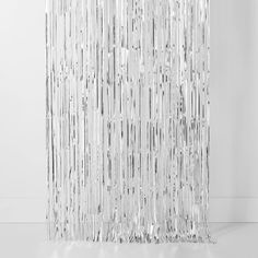 a tall glass sculpture is shown against a white wall