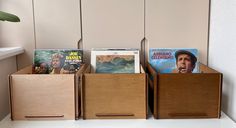 three wooden bins holding various records and magazines