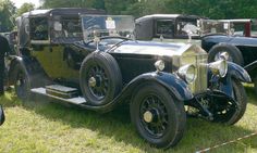 an antique car is parked in the grass