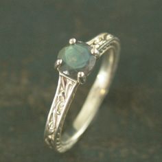 an engagement ring with a green stone in the center