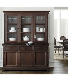 a wooden china cabinet with glass doors