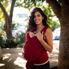 a pregnant woman standing next to a tree