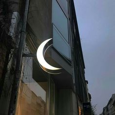 the moon is lit up in front of a building