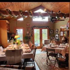 the dining room is decorated for christmas with festive garlands and lights on the ceiling