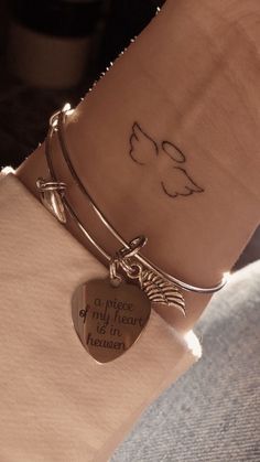 a woman's arm with a heart shaped charm on it and a message engraved on the wrist