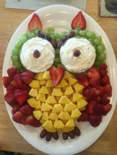 a white plate topped with fruit and an owl face