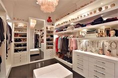 a walk in closet filled with lots of white furniture