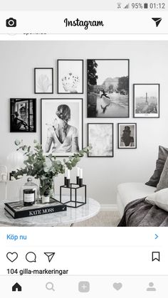 a room with pictures on the wall and flowers in vases next to a coffee table