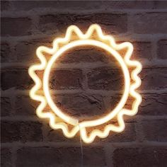 a neon light that looks like a sunflower on a brick wall in the dark