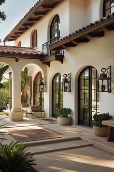 an outdoor patio with steps leading up to the front door and entry way, surrounded by potted plants