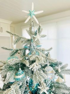 a white christmas tree with blue and silver ornaments